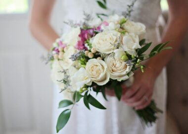brides holding white bouquet of roses