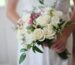 brides holding white bouquet of roses